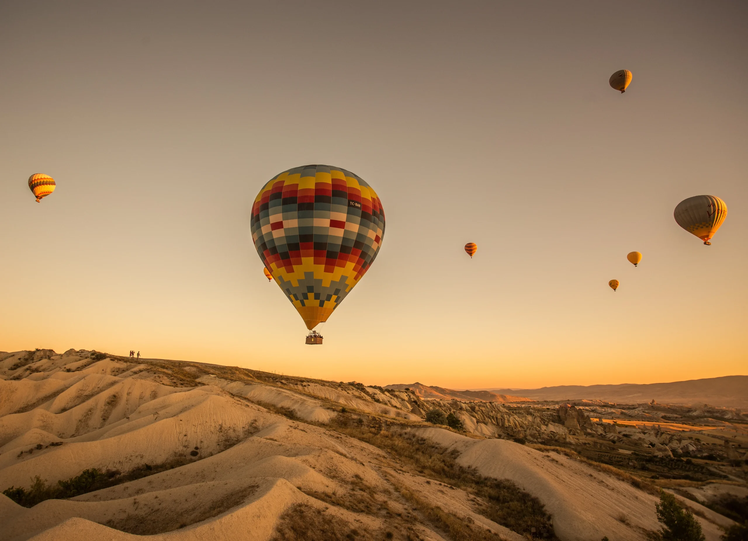 hot-air-balloons-hills-fields-sunset-cappadocia-turkey